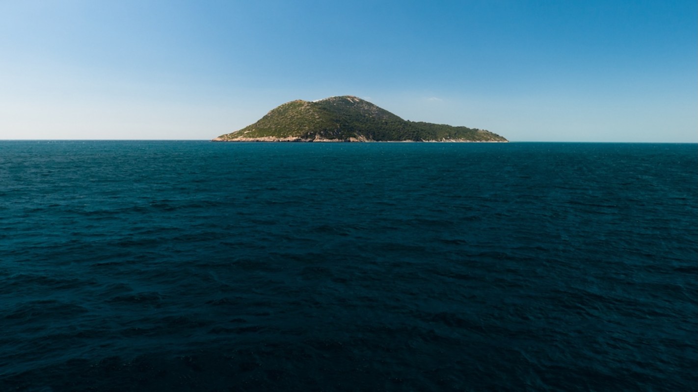 Sazan Island surrounded by water.