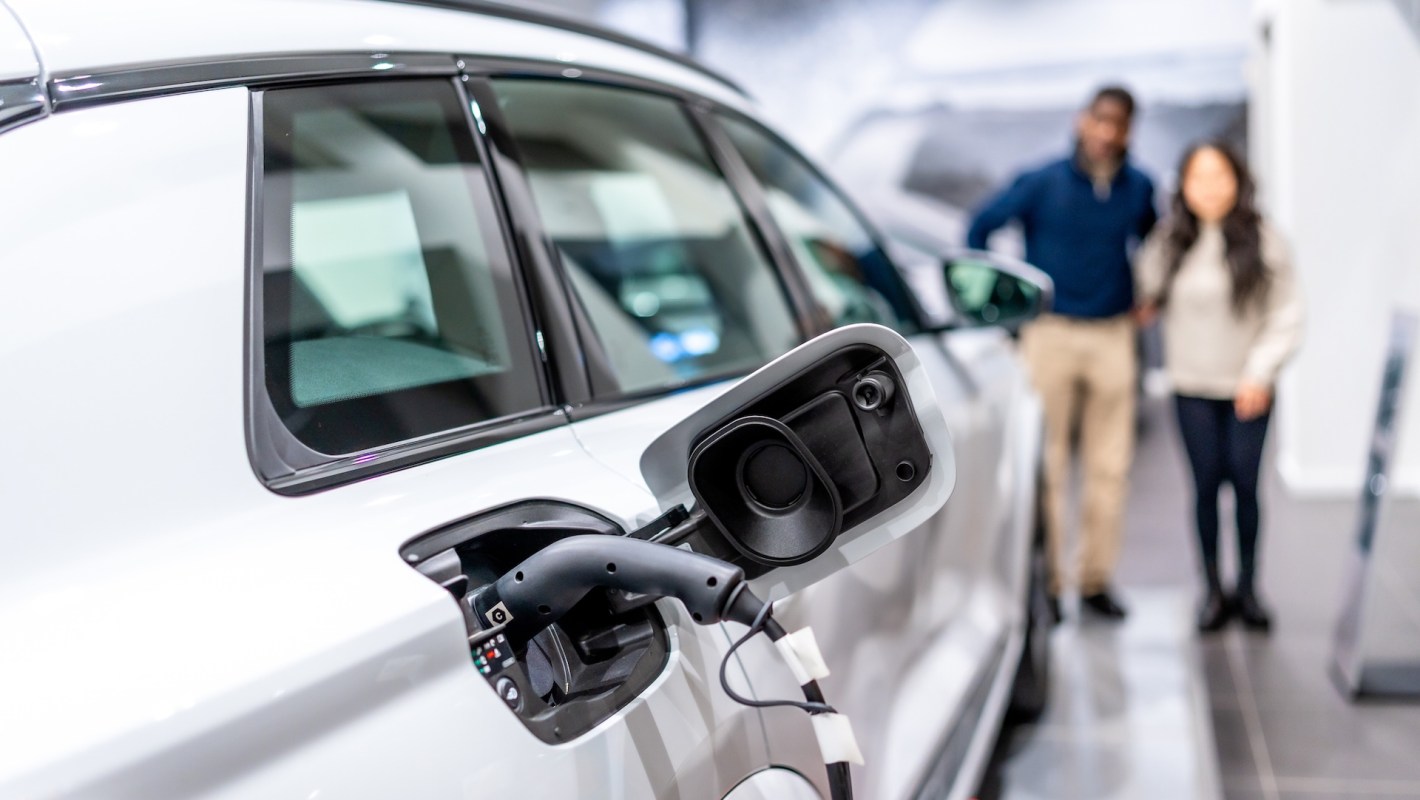 Two people looking at an EV charging port.