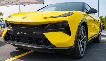 A close-up view of a vibrant yellow electric SUV parked, showcasing its sleek design and modern features.