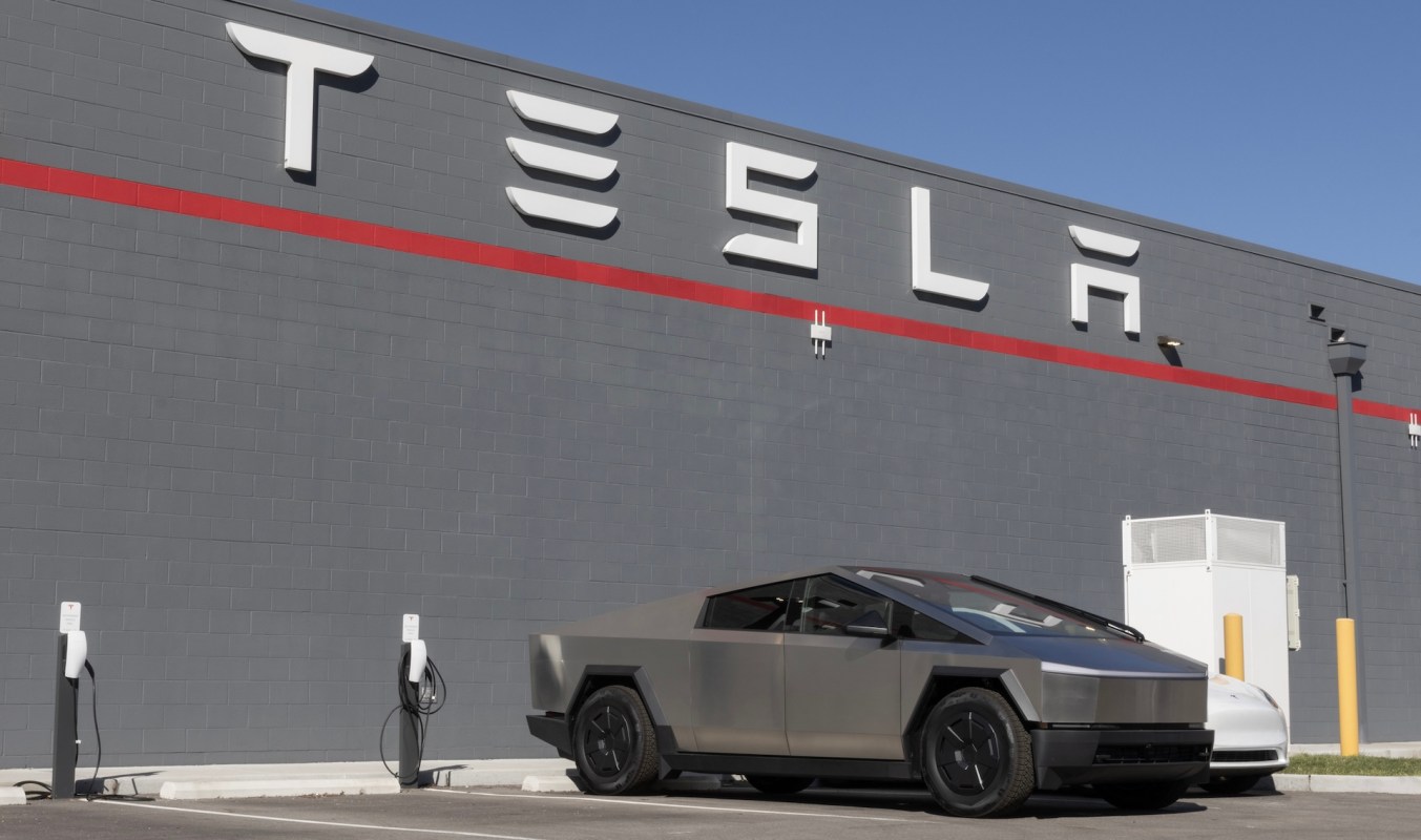 A Tesla Cybertruck is parked at an electric charging station outside a Tesla facility.