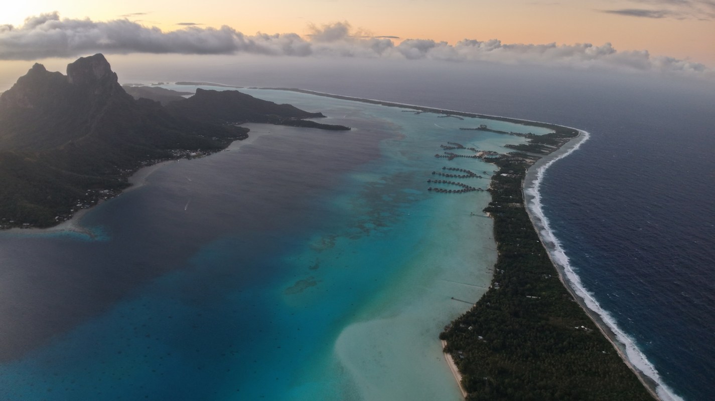 An island with mountains at sunset.