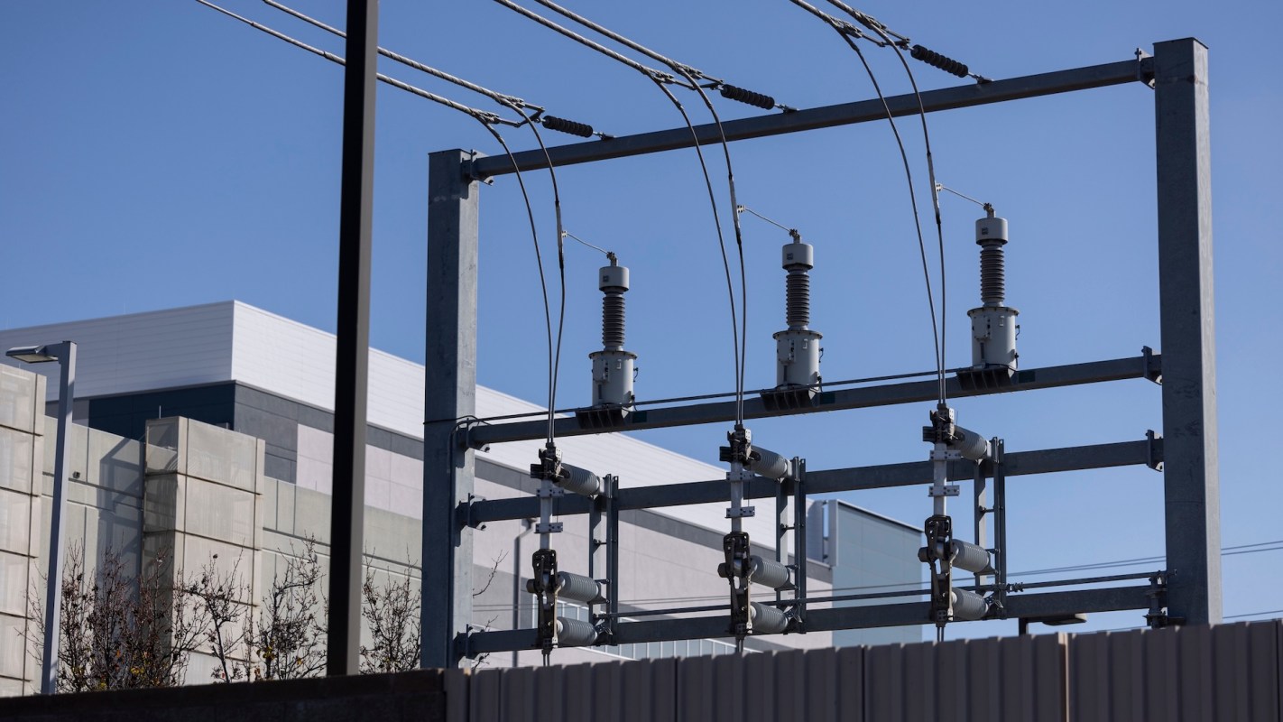 A power substation in the foreground and a data center in the background.