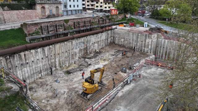 An excavation site with construction workers and machinery.