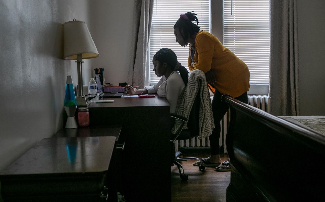 A child at a desk distance learning with their parent.