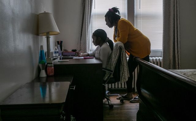A child at a desk distance learning with their parent.