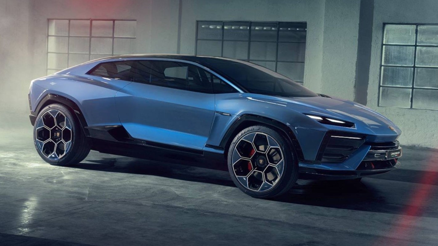 A sleek blue high-performance car with distinctive hexagonal wheels is showcased in a dimly lit garage.
