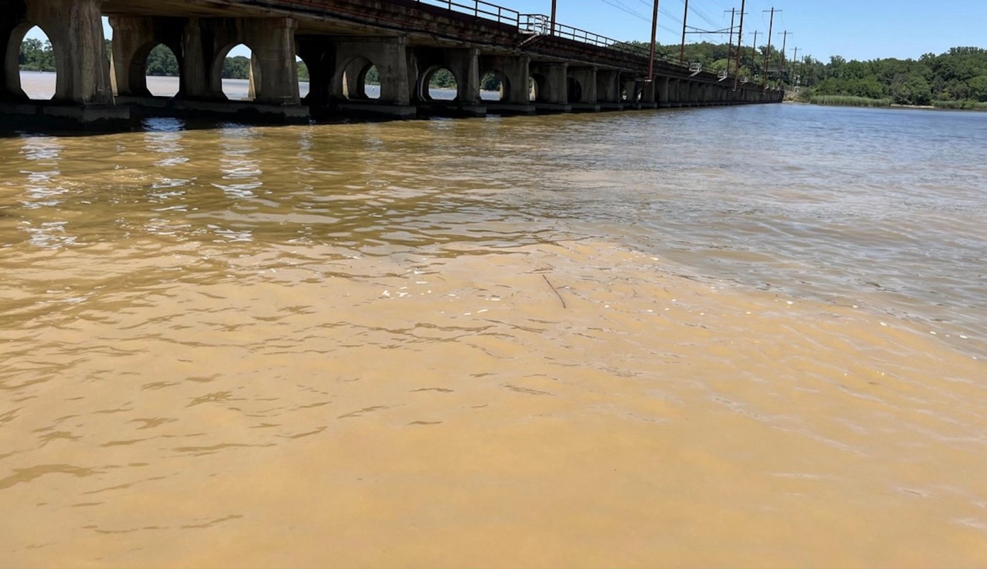 A bridge over a muddy, orangeish river.