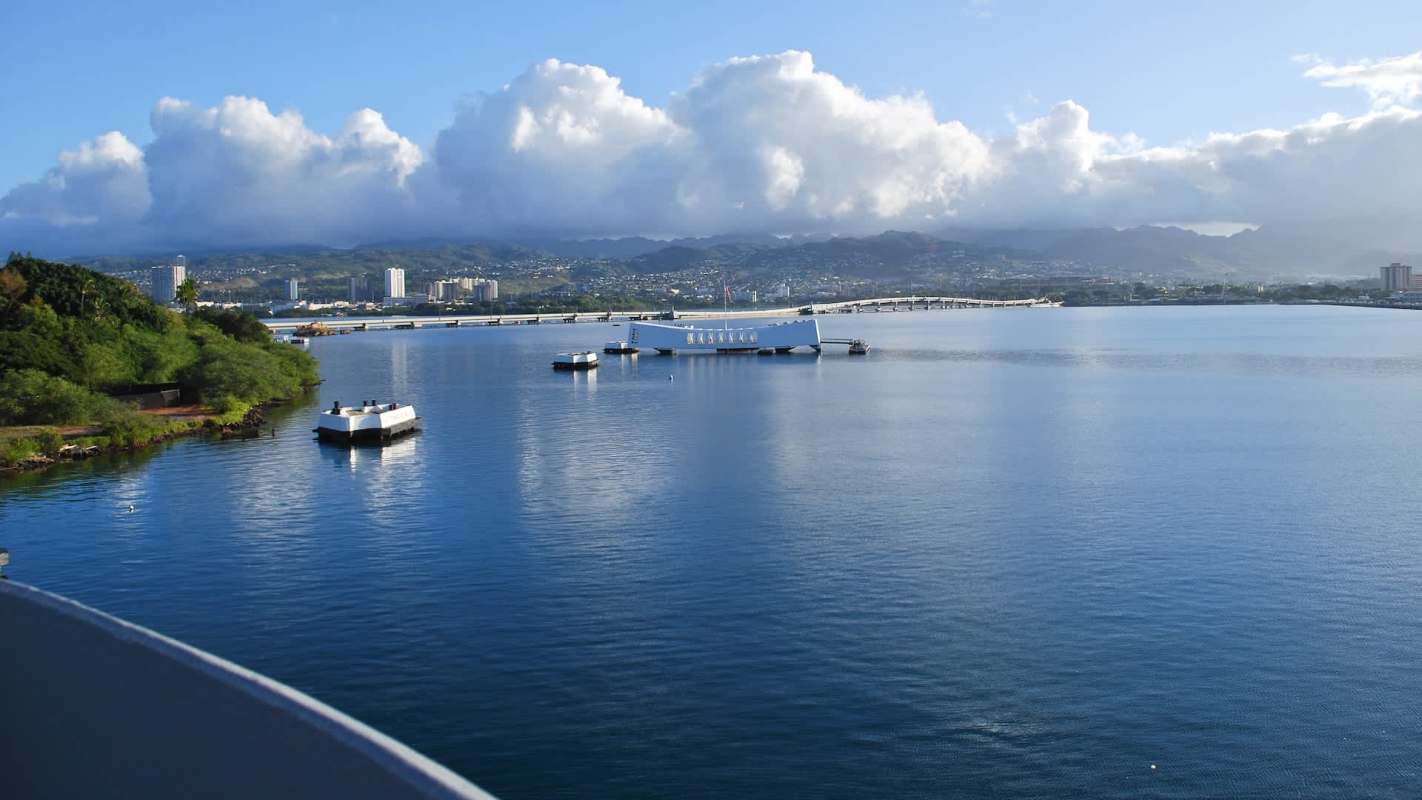A white memorial structure on the water in Pearl Harbor, Hawai'i.