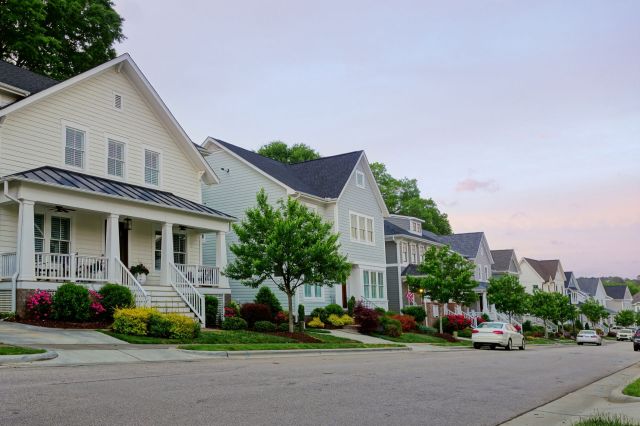 A modern neighborhood with tree-lined streets and colorful landscaping.
