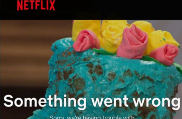 A close-up of a colorful cake topped with pink and yellow frosting flowers, with a Netflix error message displayed.