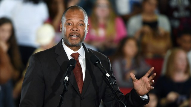 Nevada attorney general Aaron Ford speaks at a podium with microphones, gesturing toward an audience.