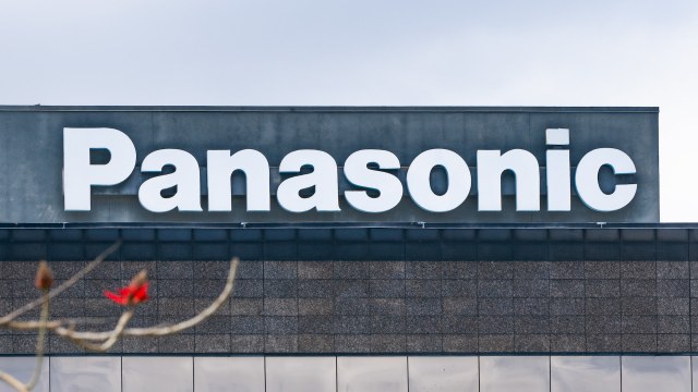 A close-up view of the Panasonic logo on a modern building against a cloudy sky.