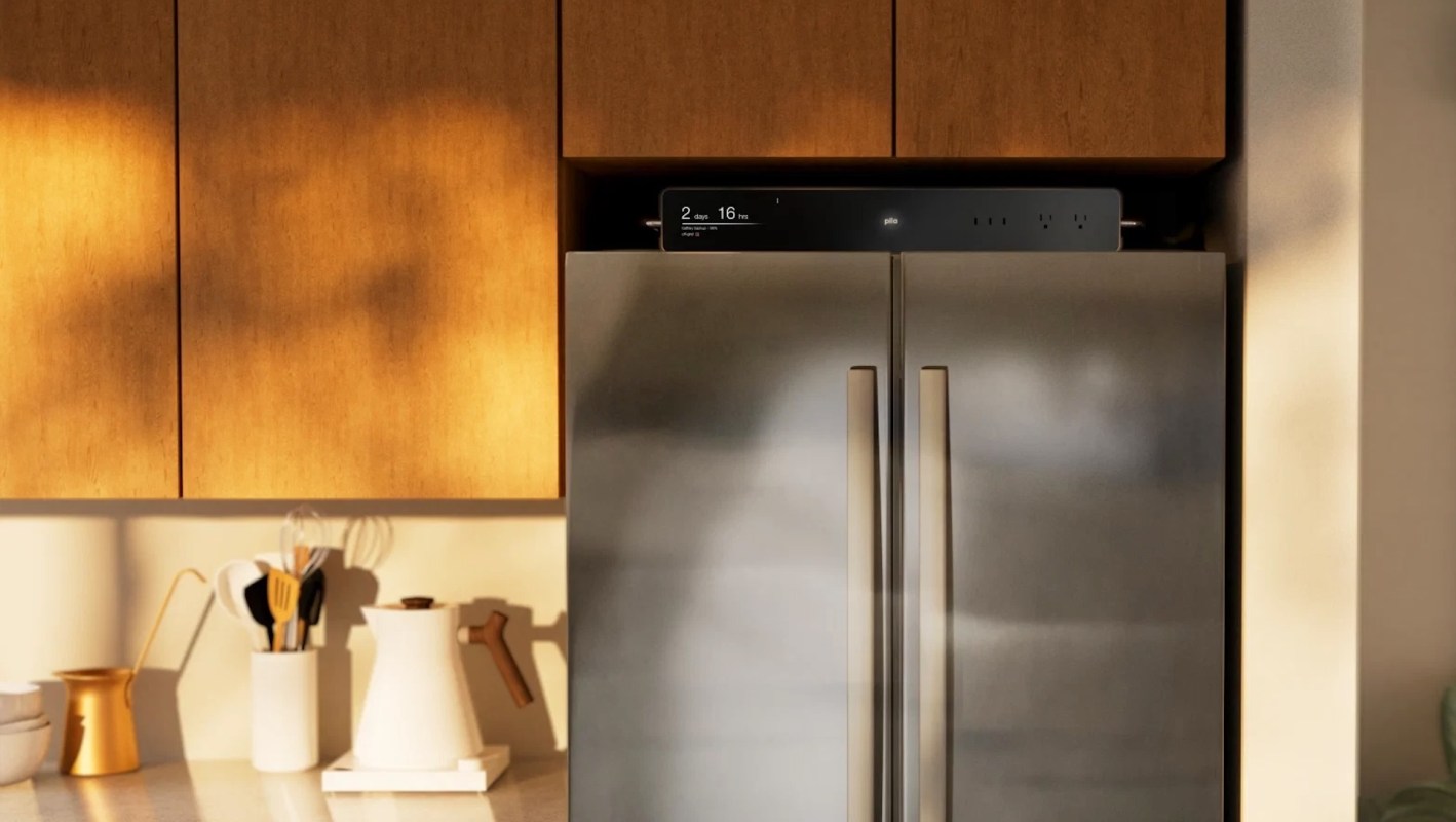A sleek stainless steel refrigerator in a modern kitchen with wooden cabinets and various kitchen utensils visible.