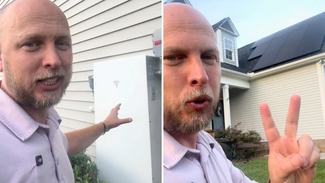 A man gestures toward a Tesla Powerwall and solar panels on a house, promoting renewable energy solutions.