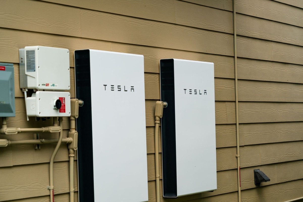 Two Tesla Powerwall units mounted outside a house.