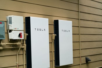 Two Tesla Powerwall units mounted outside a house.