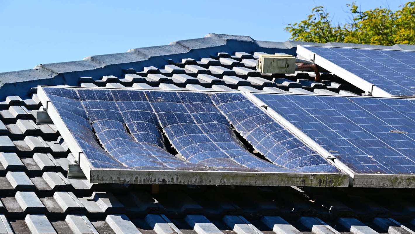 Damaged solar panels on a tiled roof.