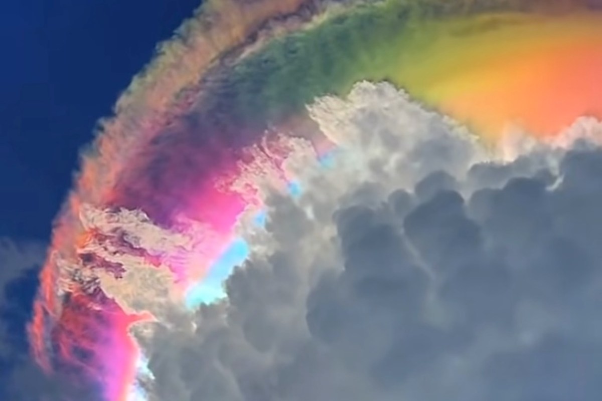 A vivid cloud formation displaying a rainbow of iridescent colors against a blue sky.