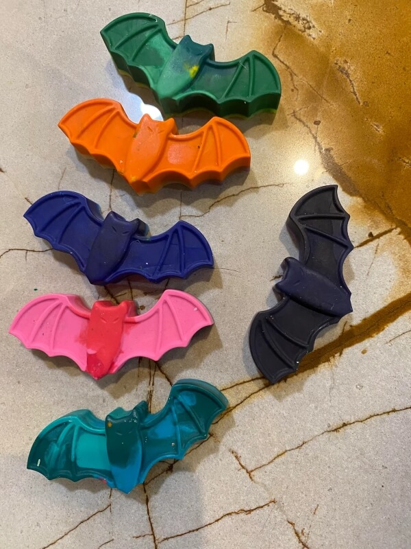 Crayons molded into green, orange, purple, pink, blue, and black bats.