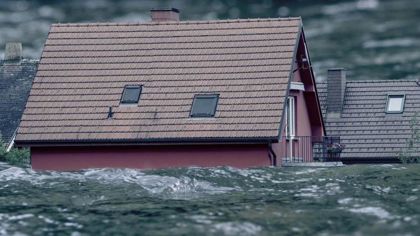 Water almost reaches the roof of a house after flooding.