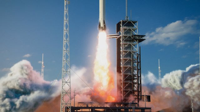 A rocket launching into a clear blue sky, leaving behind a trail of flames and smoke.