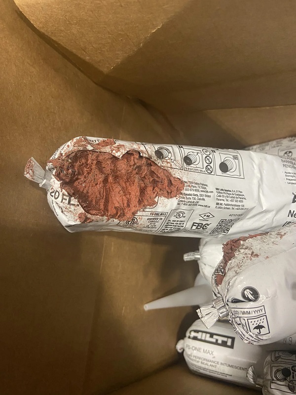 Several sealed bags of Hilti construction materials are partially visible inside a brown cardboard box.