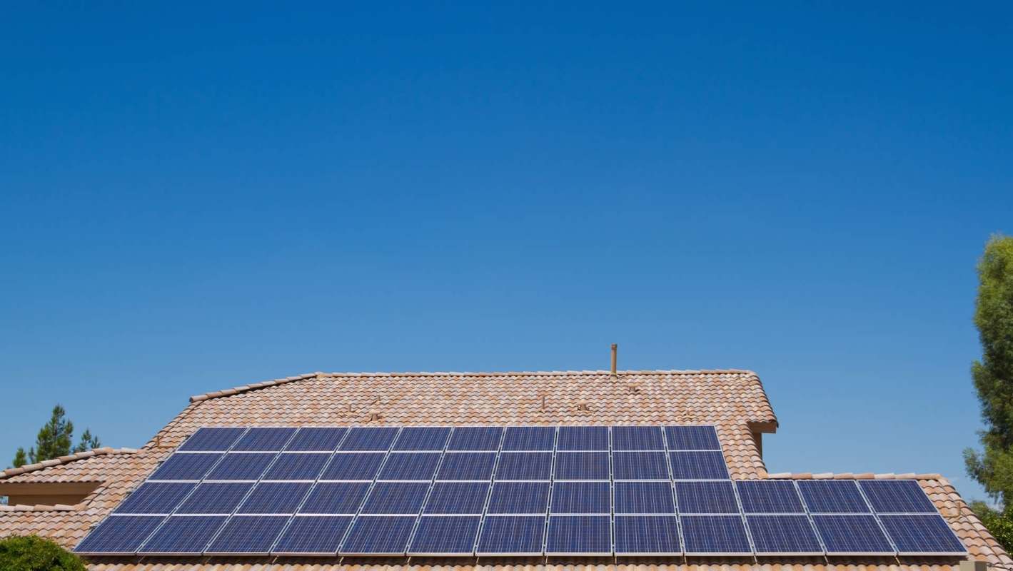 A rooftop equipped with solar panels under a clear blue sky.