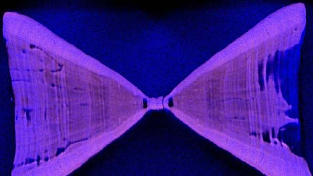 An abstract image of two symmetrical, triangular shapes against a dark background, illuminated in purple hues.