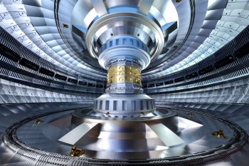 A futuristic metallic chamber with a large, intricate circular core and robotic elements on the floor.