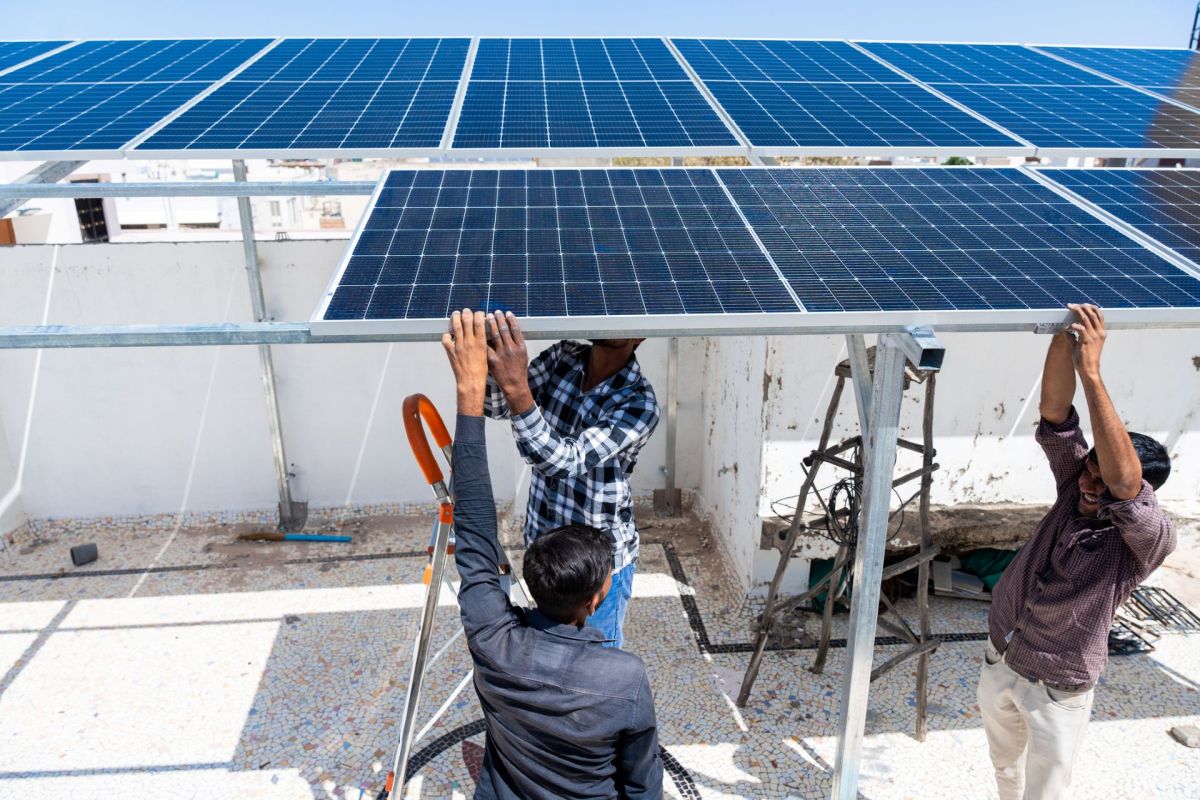 People installing solar panels in India.