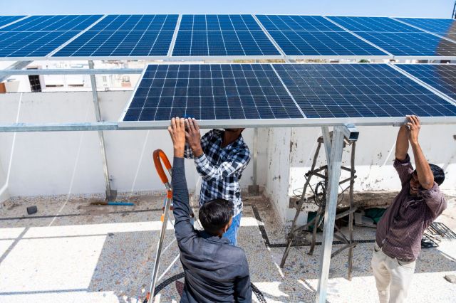 People installing solar panels in India.