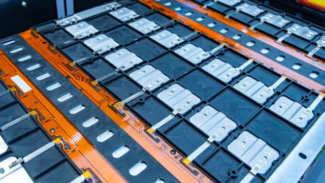 Close-up of an electric vehicle battery pack with multiple cells arranged in a grid formation.