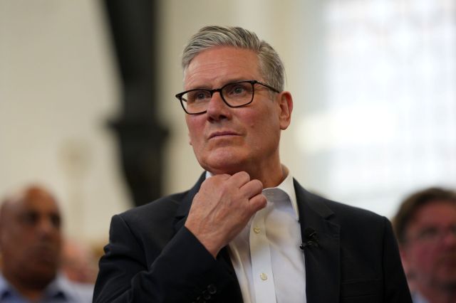 Keri Starmer holding his chin during a discussion event.