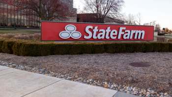 A large red sign displaying the State Farm logo and name in front of a landscaped area.