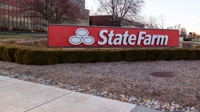 A large red sign displaying the State Farm logo and name in front of a landscaped area.