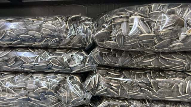 Several packages of sunflower seeds stacked in a dark storage space.