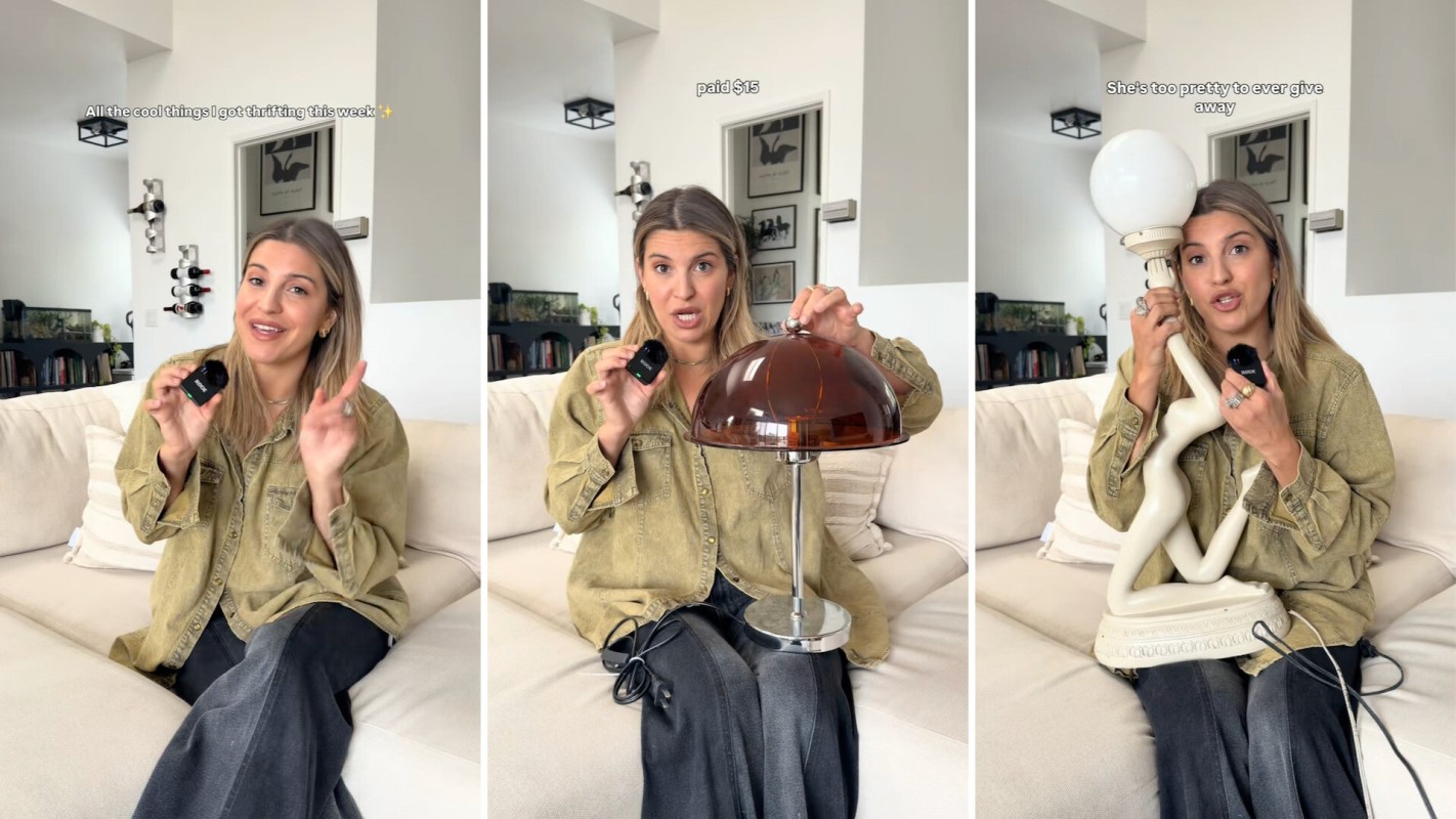 A woman showcases thrifted items, including a lamp and a decorative figure, while seated on a cozy couch.