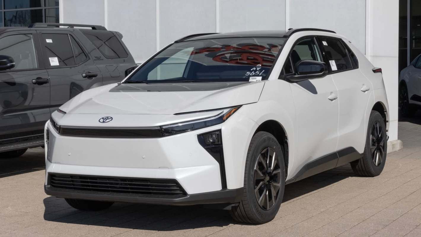 A white Toyota SUV parked outside a dealership, showcasing a modern design and black wheels.