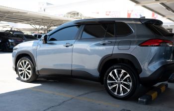 A gray SUV parked in a lot with tinted windows and alloy wheels, under a covered area.