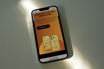 A smartphone displaying a promotional screen for pre-ordering the "T1" phone by Trump Mobile.
