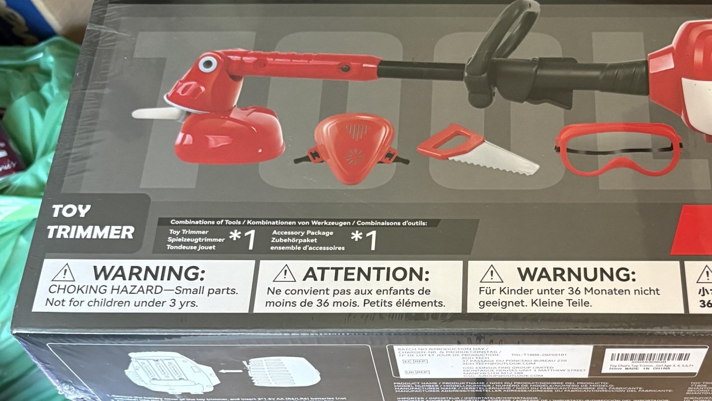 A box featuring a toy trimmer and accessories, with warning labels about choking hazards for small parts.