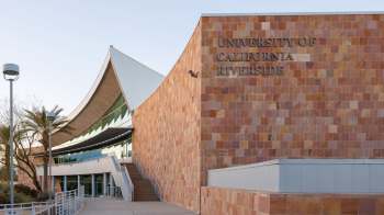 A modern building facade with natural stone and a sign for the University of California, Riverside.