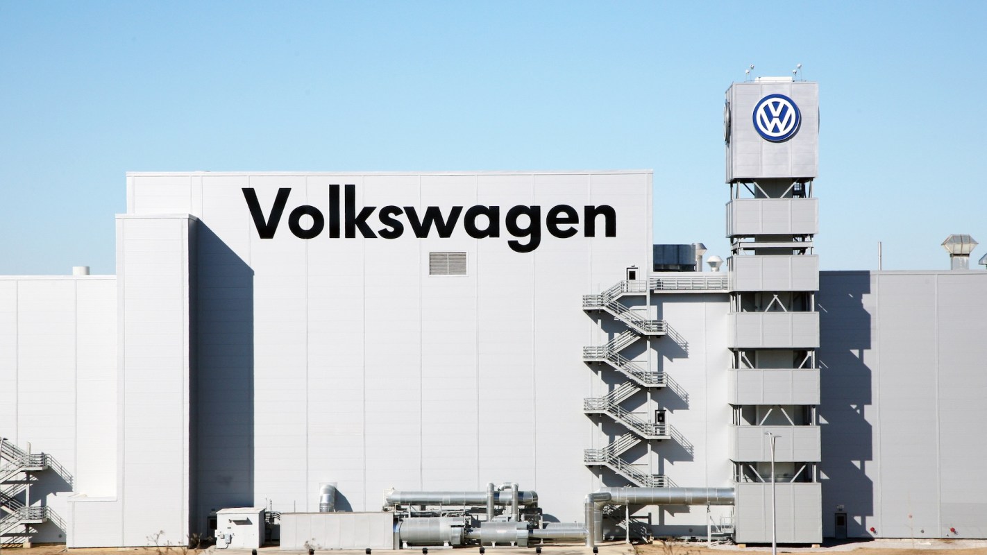 A white Volkswagen building with a tall staircase in front.