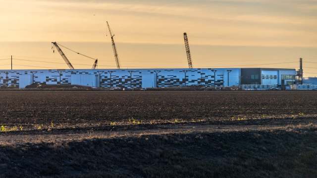 A large data center under construction at sunset.