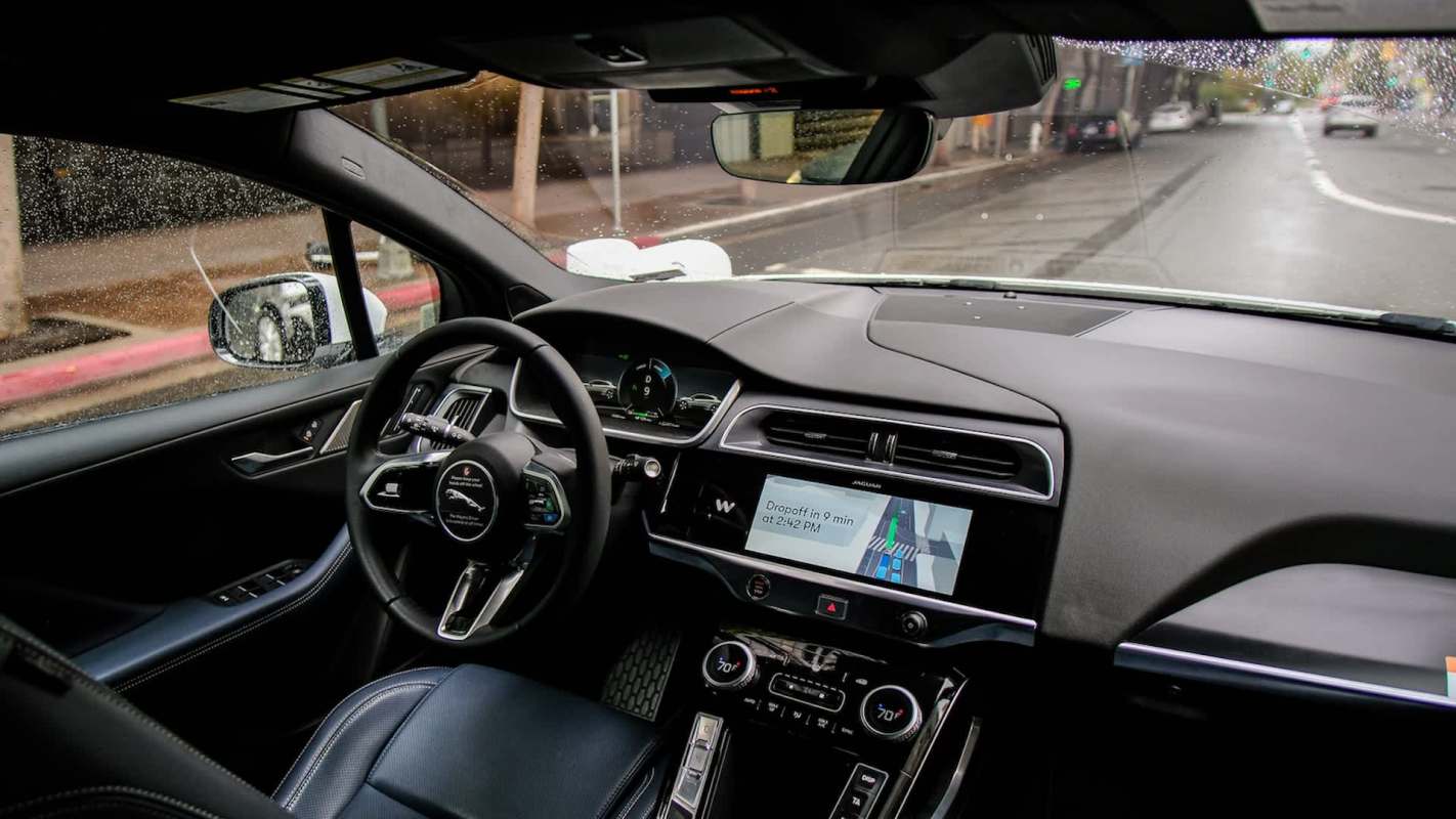 The interior of an autonomous car with a navigation screen showing the estimated drop-off time.