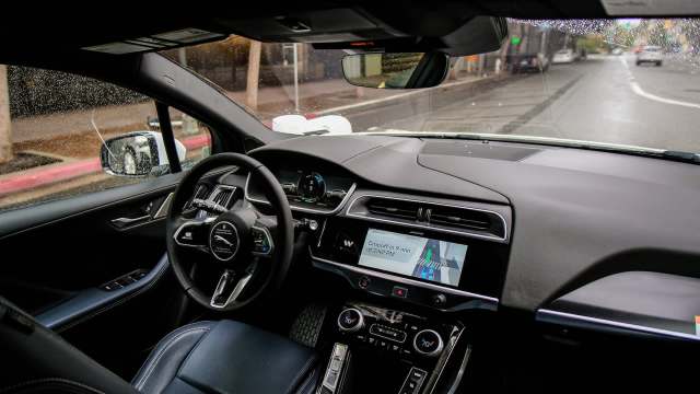 The interior of an autonomous car with a navigation screen showing the estimated drop-off time.