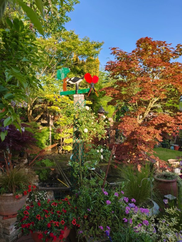 A vibrant garden with modern artwork standing tall.