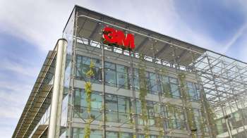 A modern glass building with a prominent red 3M logo against a blue sky.