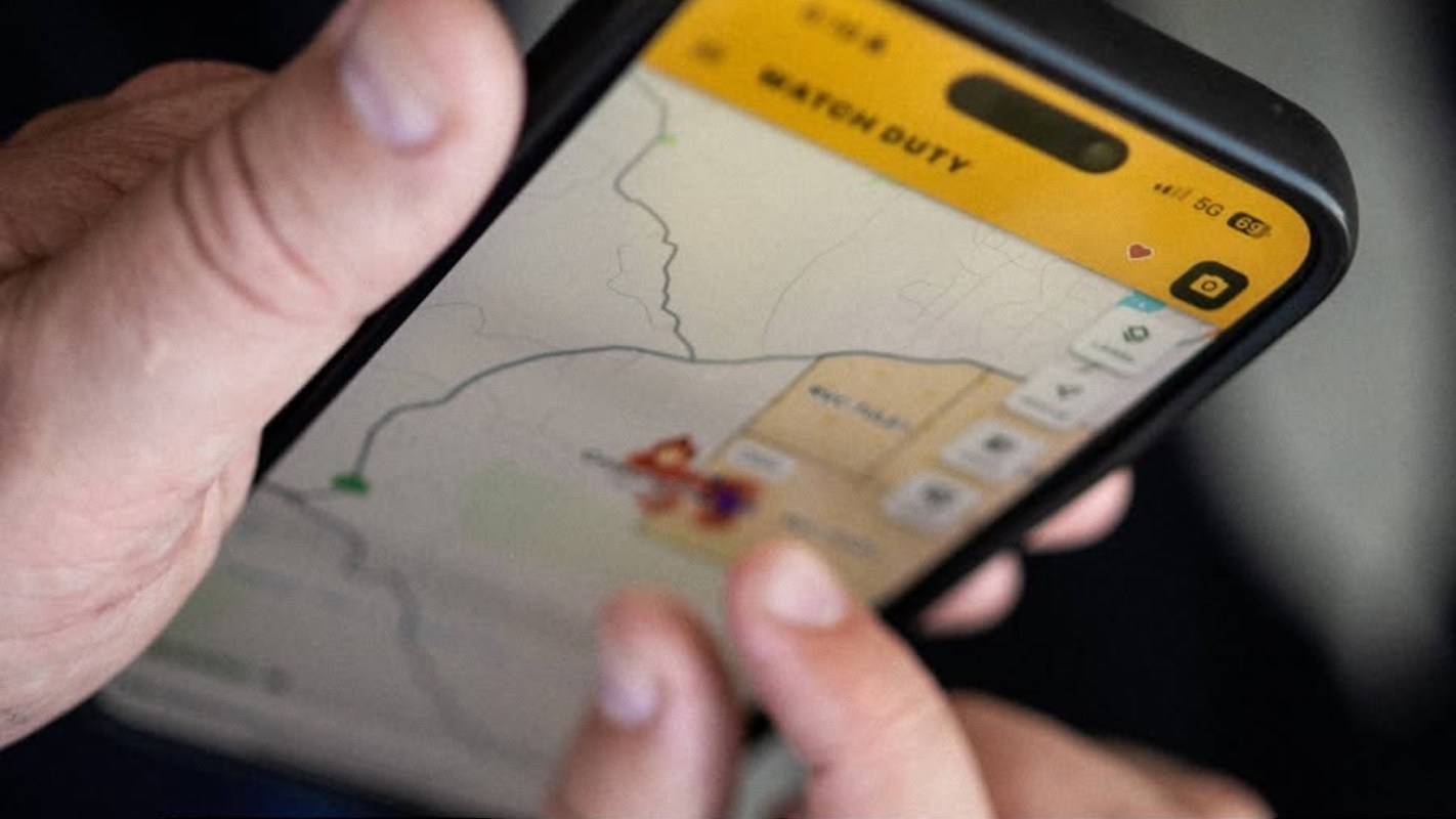 A person interacting with a Watch Duty app on a smartphone.