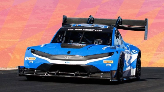 A blue Ford racing car speeds along a track.